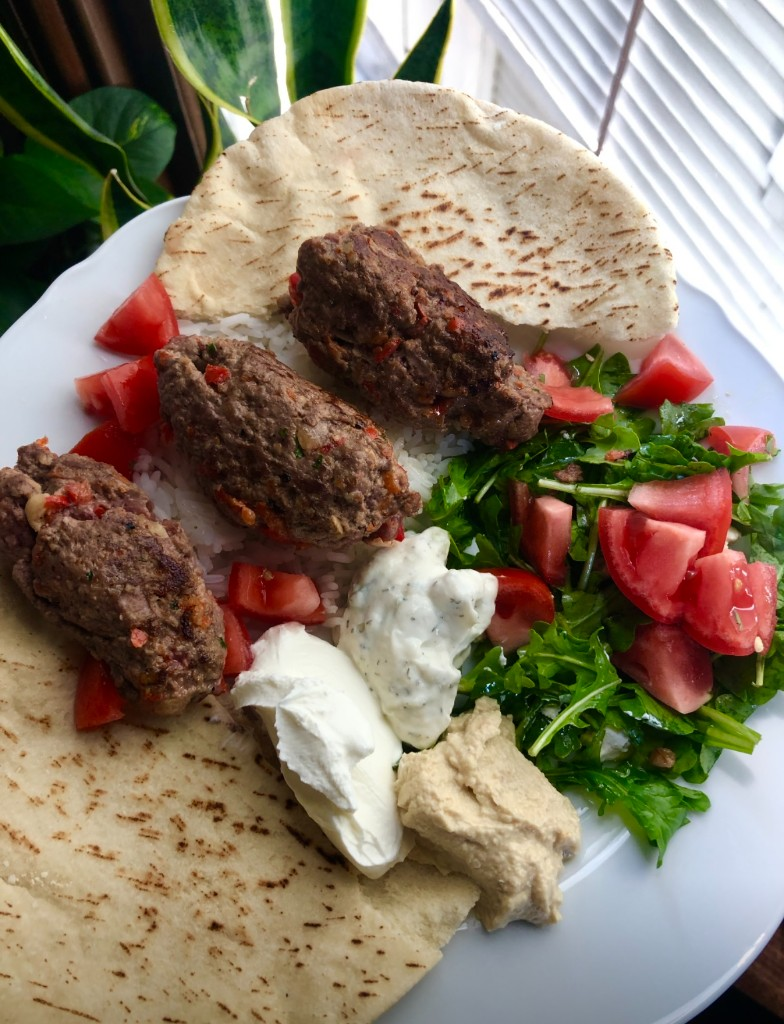 Plate with pita, rice, ground beef, tzatziki, labneh, hummus, and arugula