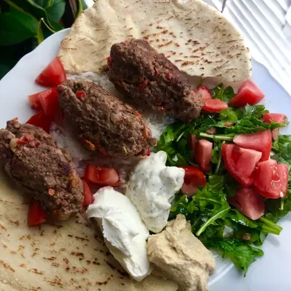 Plate with pita, rice, ground beef, tzatziki, labneh, hummus, and arugula